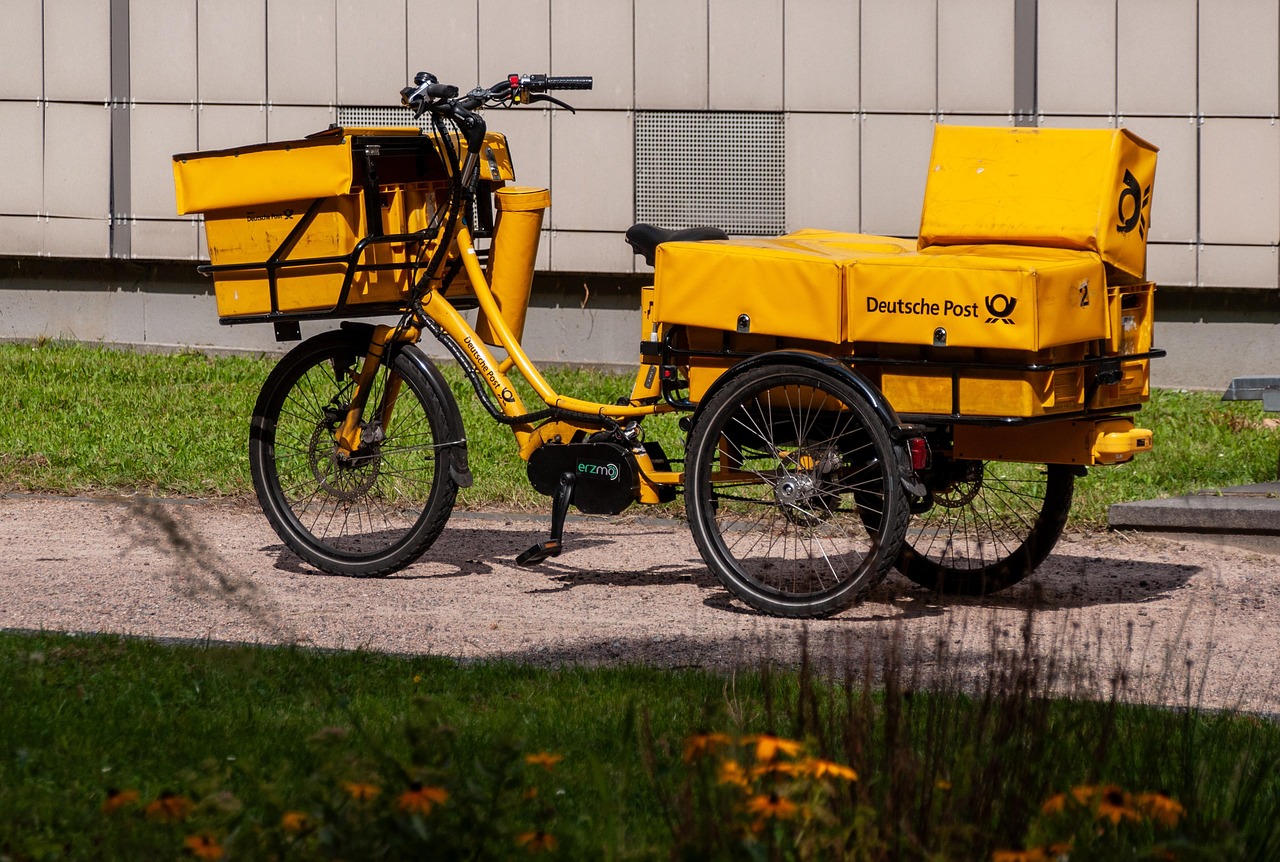 Gele bezorgfiets van Deutsche Post met fietstassen.